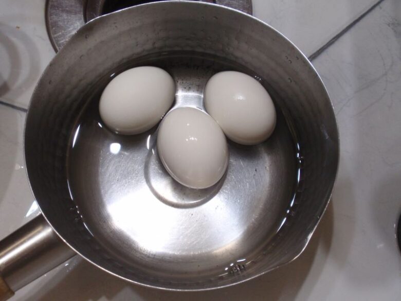 固ゆで卵の殻の剥き方　冷ました卵と少しの水を鍋に入れます。