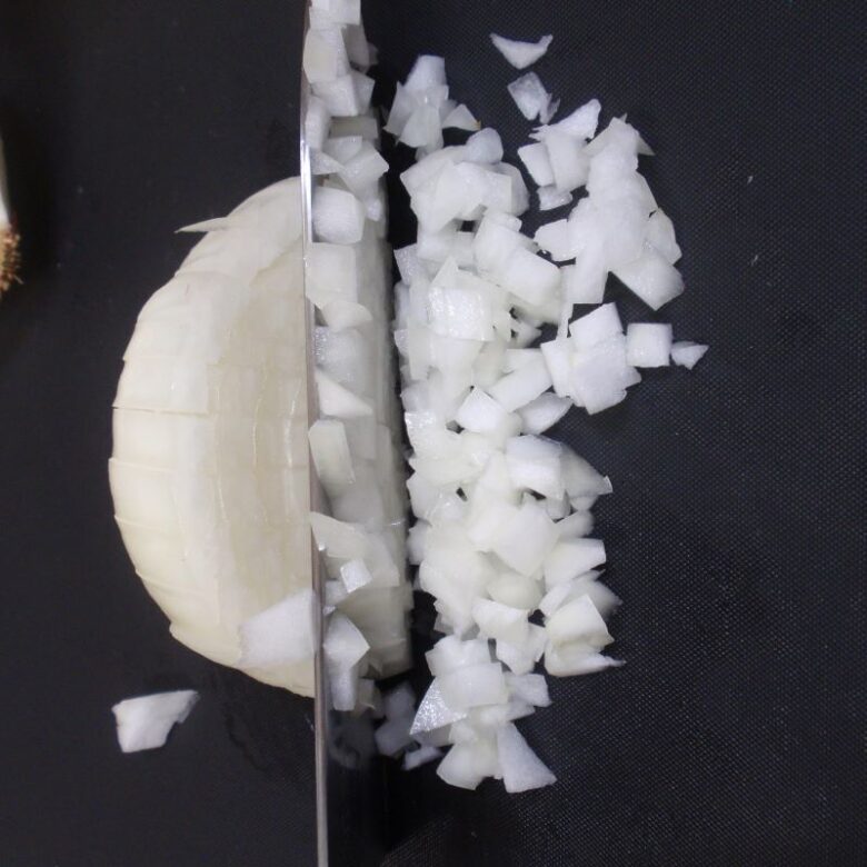 玉ねぎのみじん切りの作り方　６　縦横に溝を入れた玉ねぎを切ります。