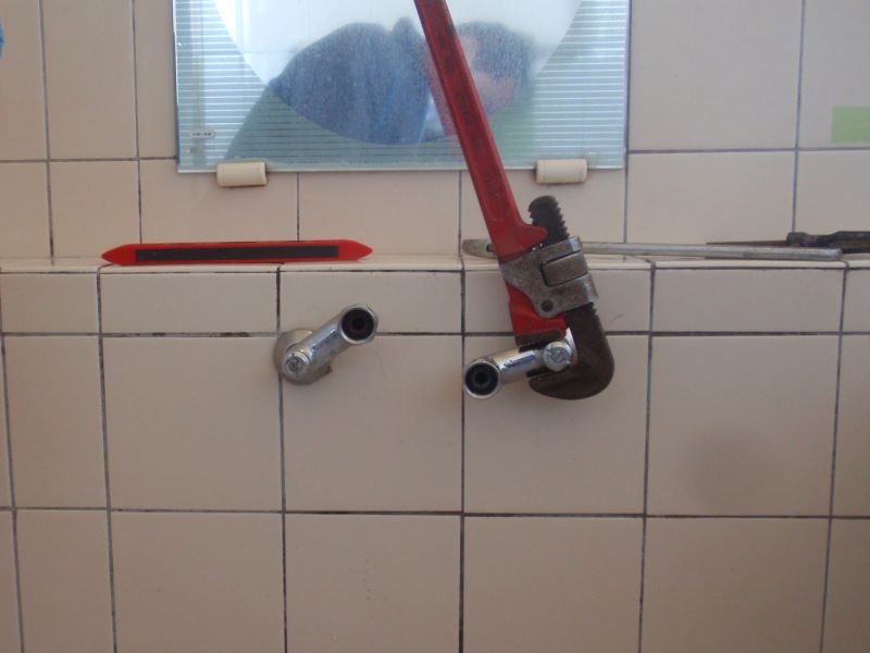 浴室のシャワー付き混合水栓の　取付脚取り外し　パイプレンチを使ってネジを緩めます。