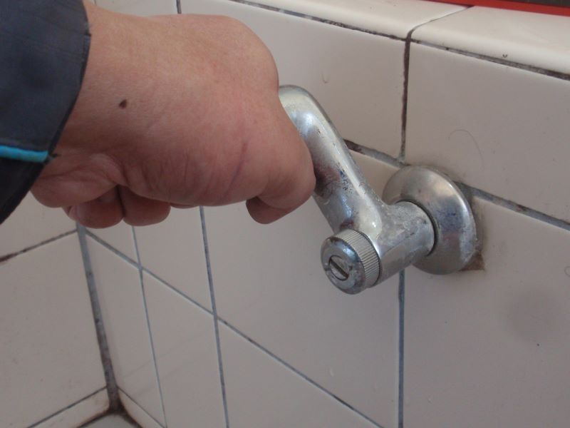 浴室のシャワー付き混合水栓の　取付脚取り外し　パイプレンチでネジを少し緩めた後手で取付脚を回して取り外します。