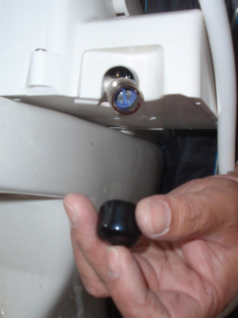温水洗浄便座（通称ウォシュレット）の取り付け方法⑪温水洗浄便座本体のホース取り付け部の保護キャップを取り外し。