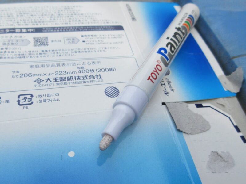 厚紙にペン先をゆっくり押し付けてホワイトインクを染み込ませる作業